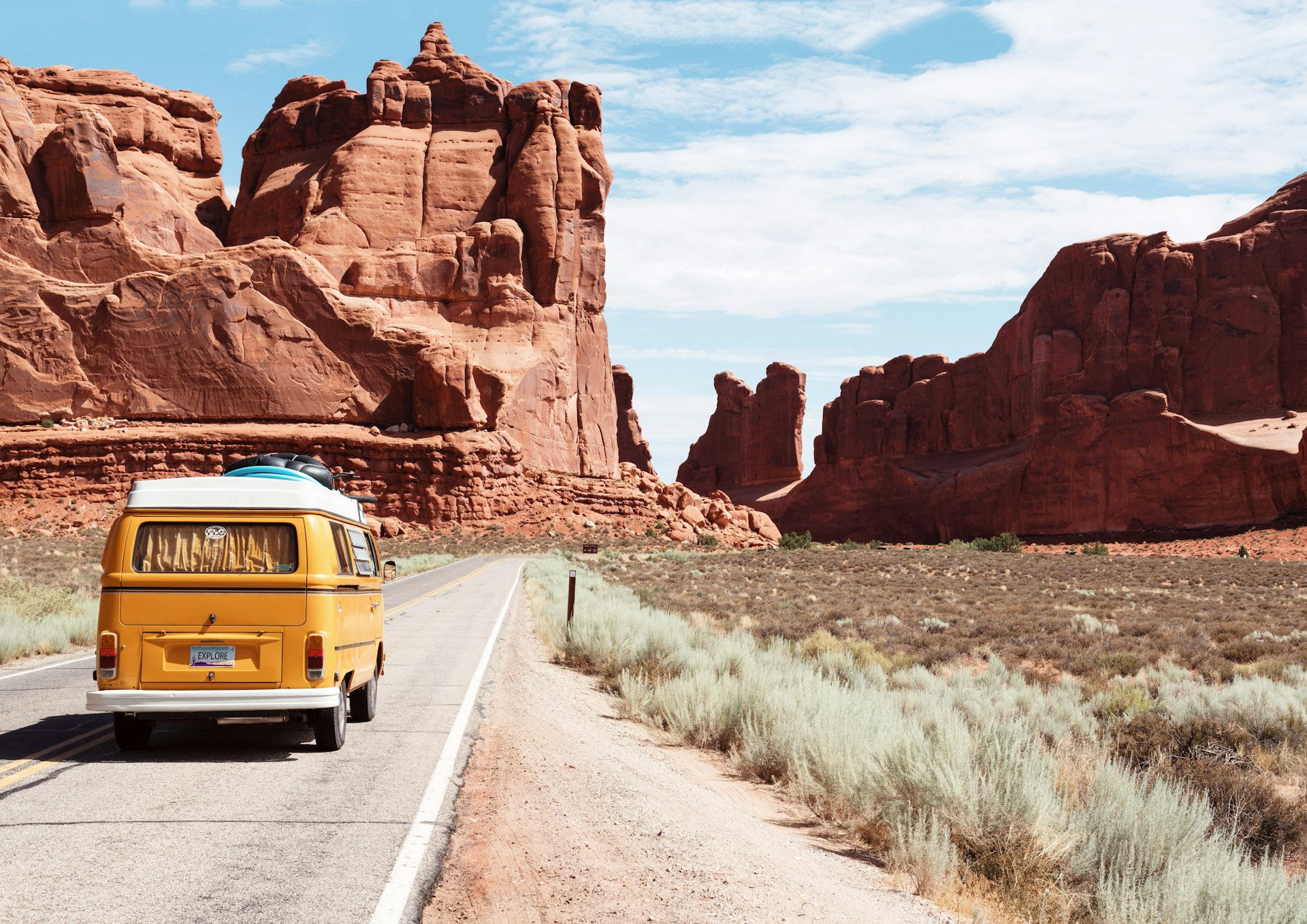Campervan driving an open road through red rock country