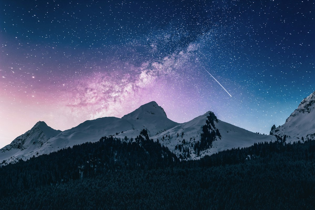 Snowy peaks under a starry night sky