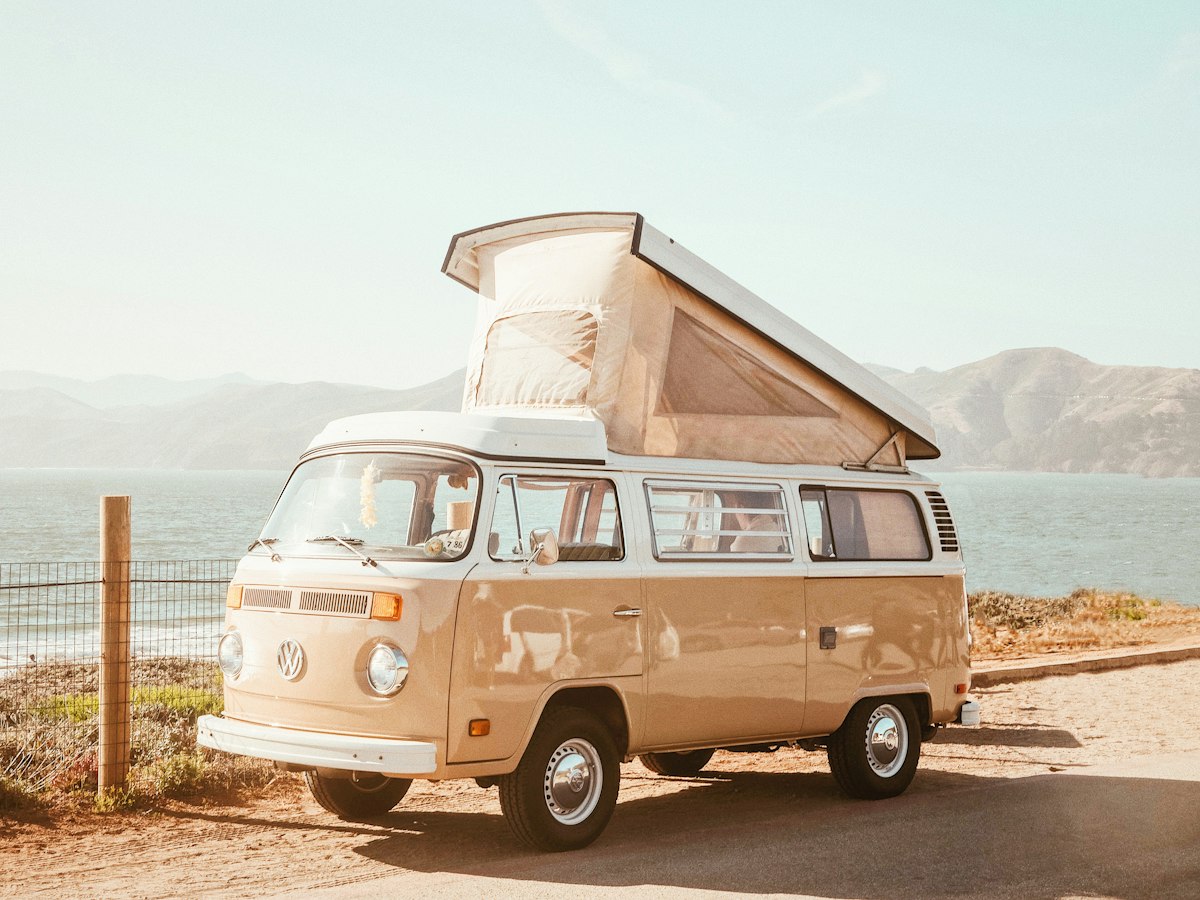 Compact pop-top campervan parked by the coast