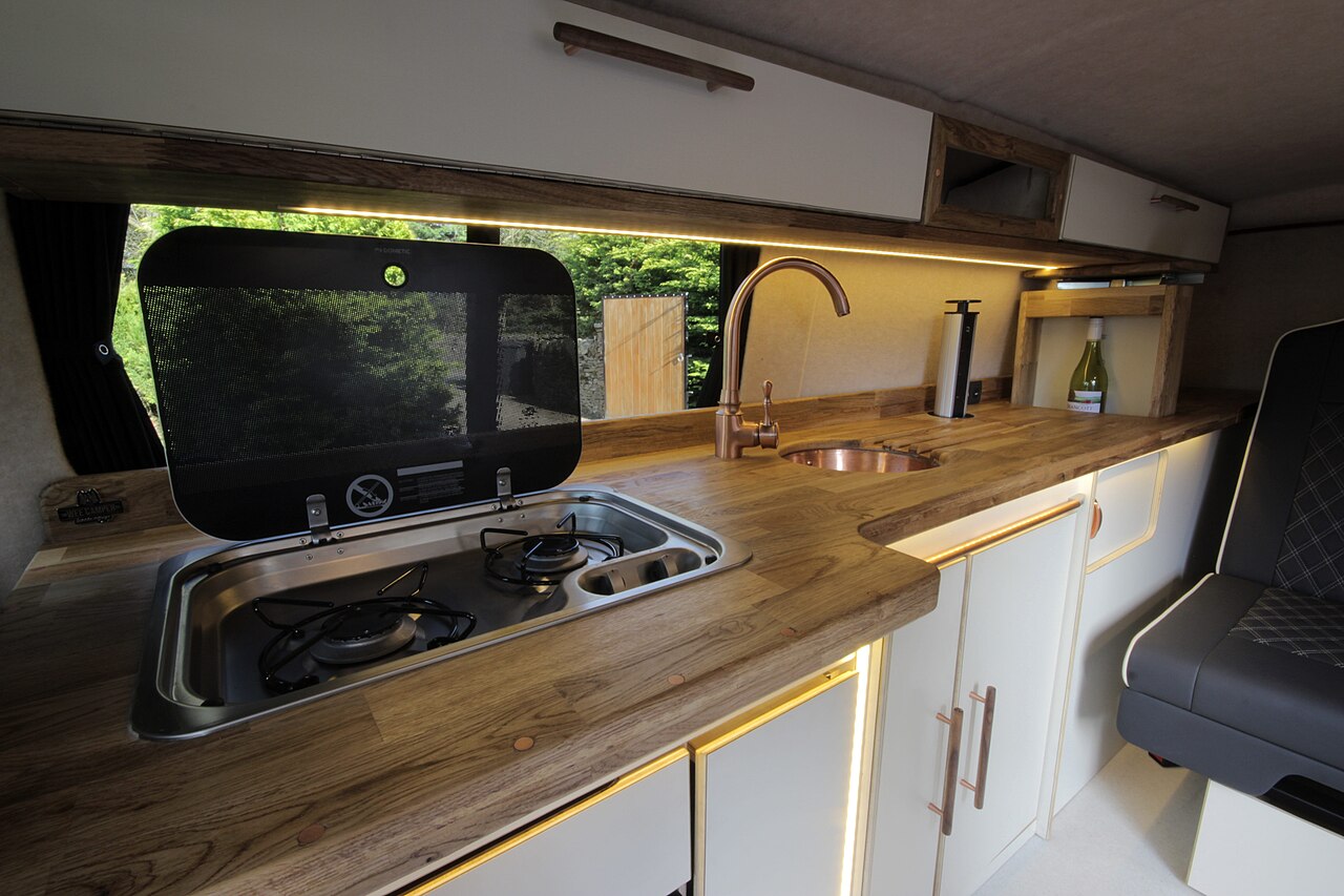 Campervan kitchen with stove and wooden worktop